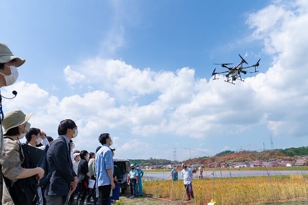 学生がドローンを見上げている写真